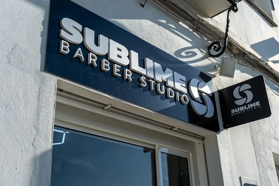 Fachada de Sublime Barber Studio con el letrero iluminado