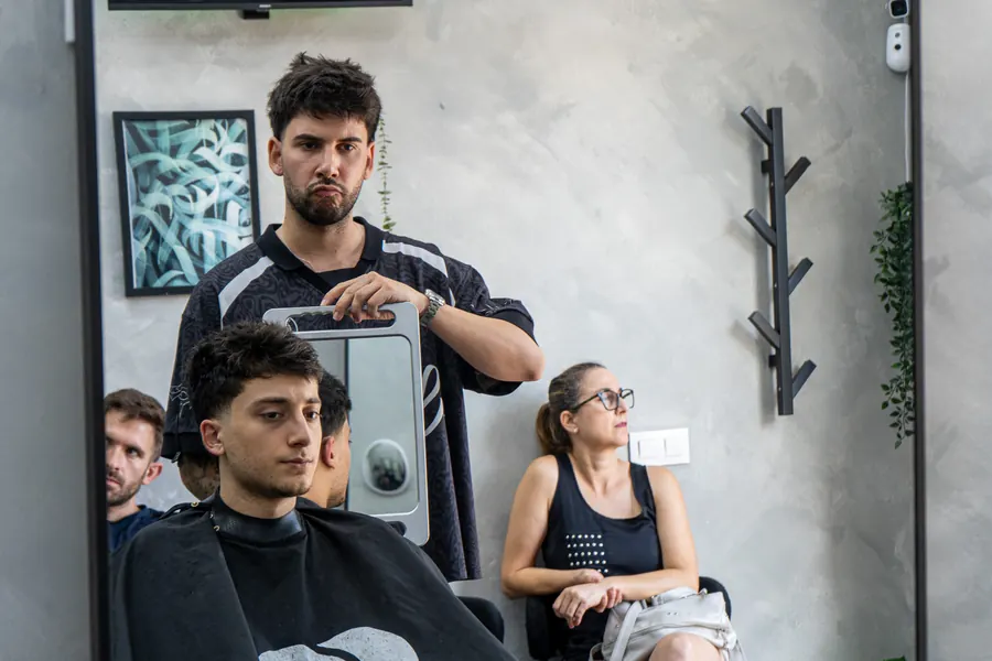 Javi enseñando al cliente el resultado con el espejo de mano